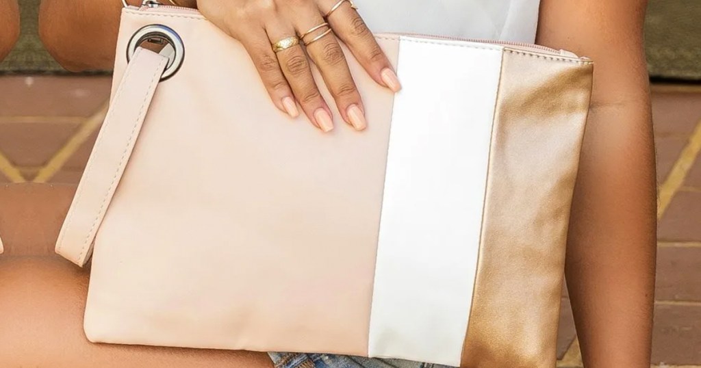 woman holding large pink clutch