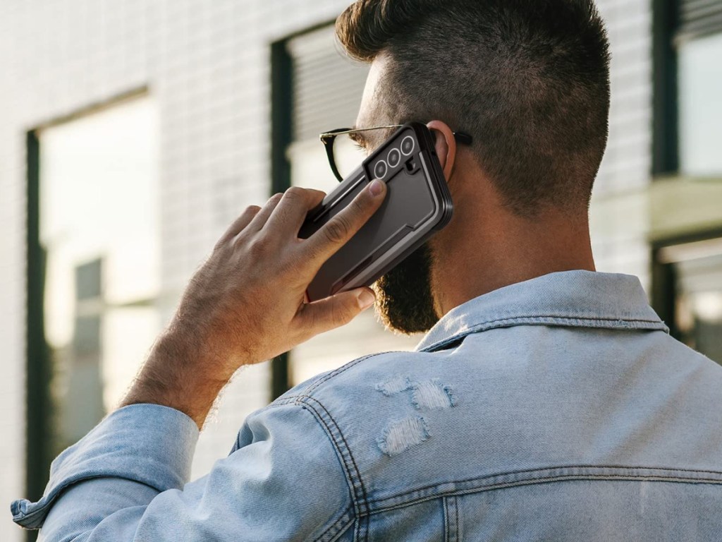 man holding Samsung Galaxy 22 phone in black case to ear