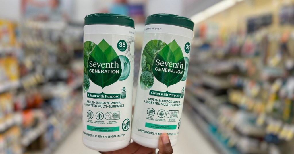 hand holding up two bottles of Seventh Generation Wipes