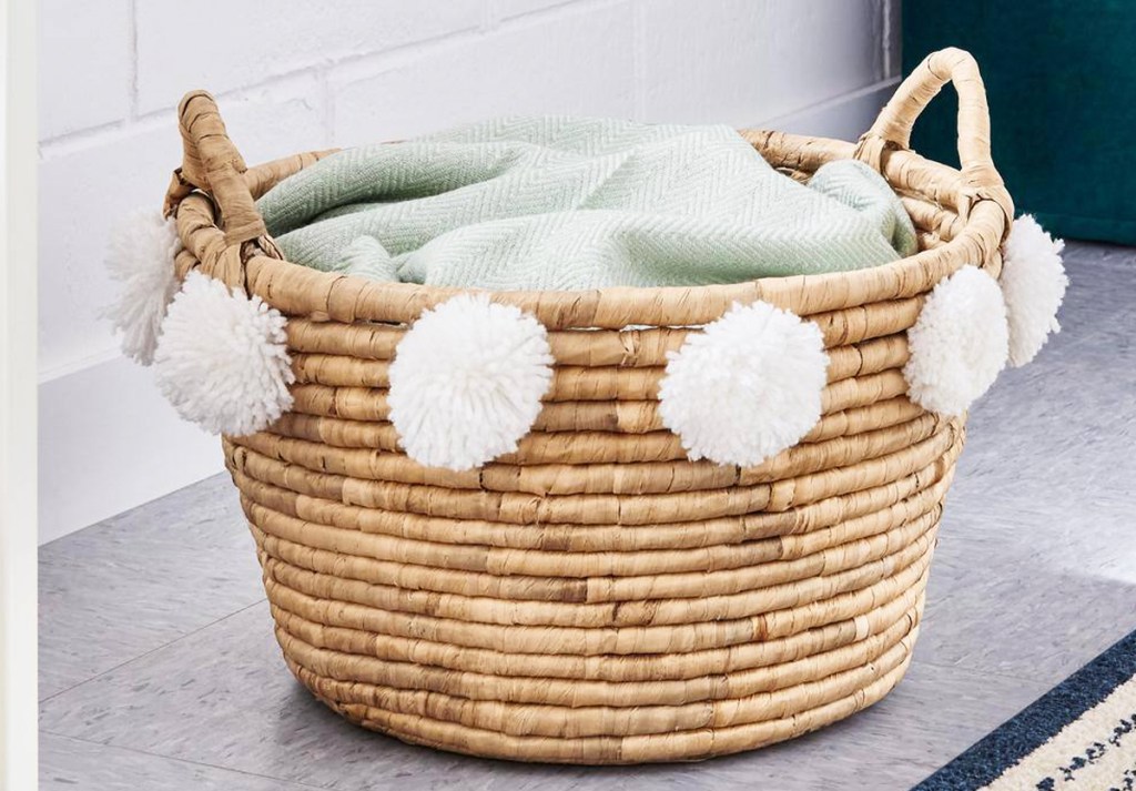 woven basket with white pom poms