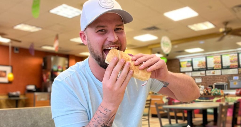 man eating a Subway sandwich