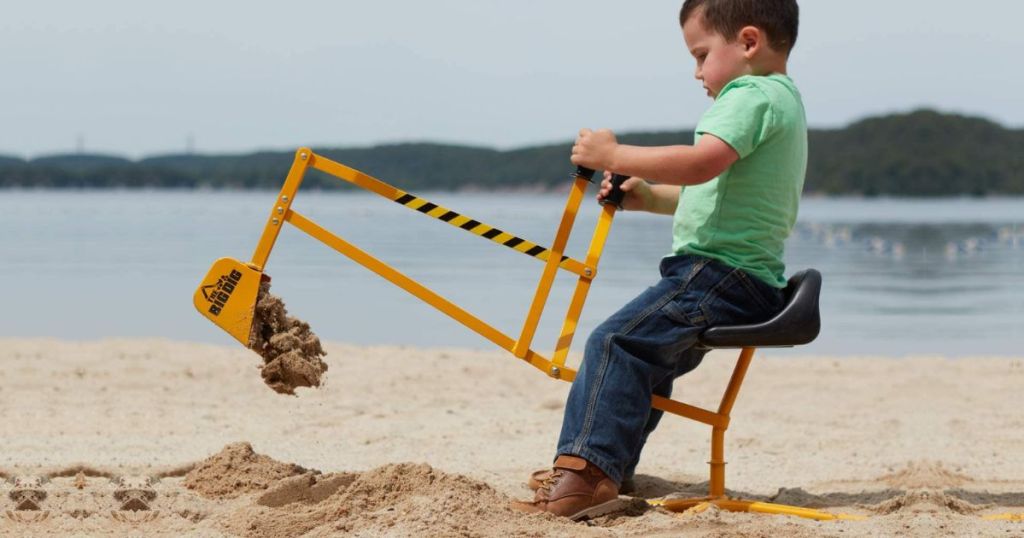 Little boy digging in the sand with The Big Dig 