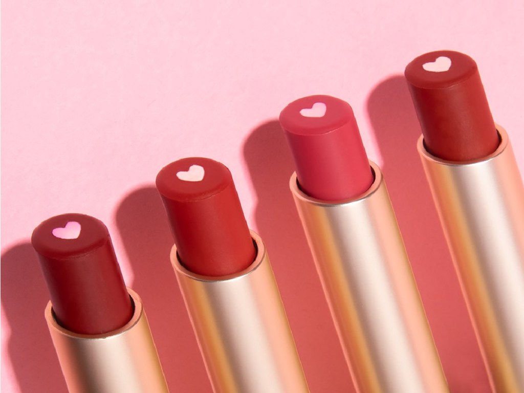 four lipsticks in different shades with heart center