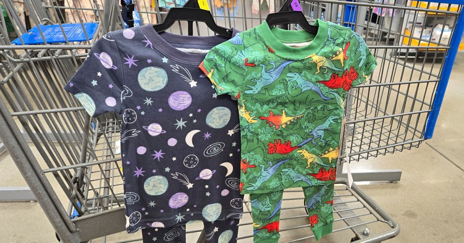 space and dinosaur print pajama sets hanging from a cart
