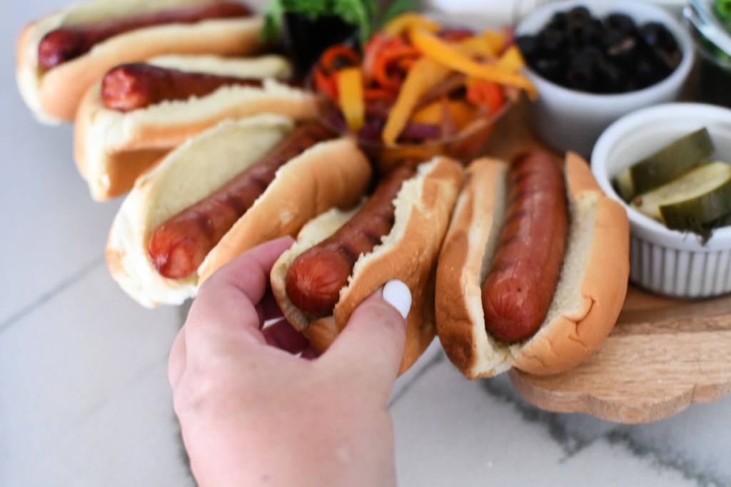 adding hot dogs to buns