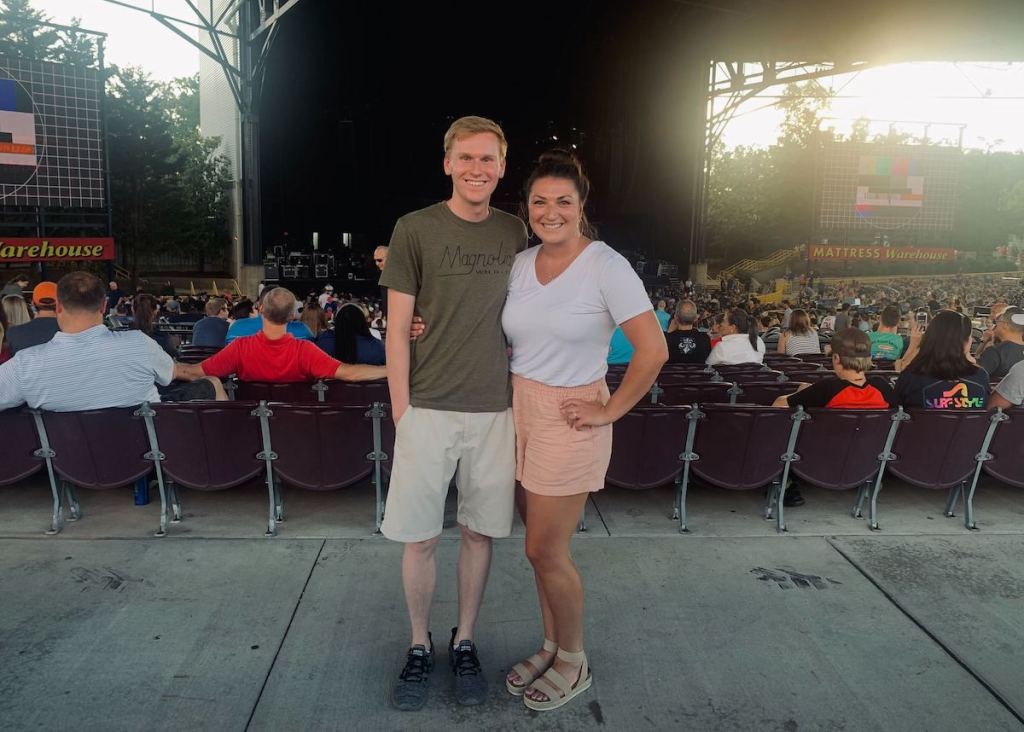 man and woman standing outside at concert venue