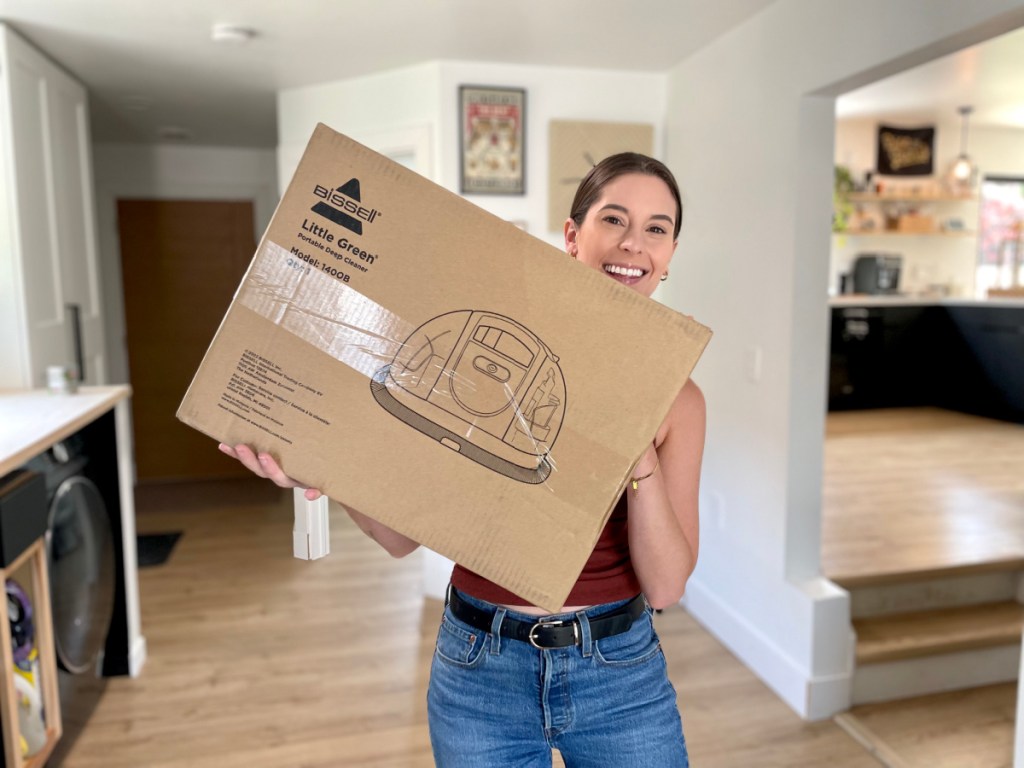 smiling woman holding a little green machine box