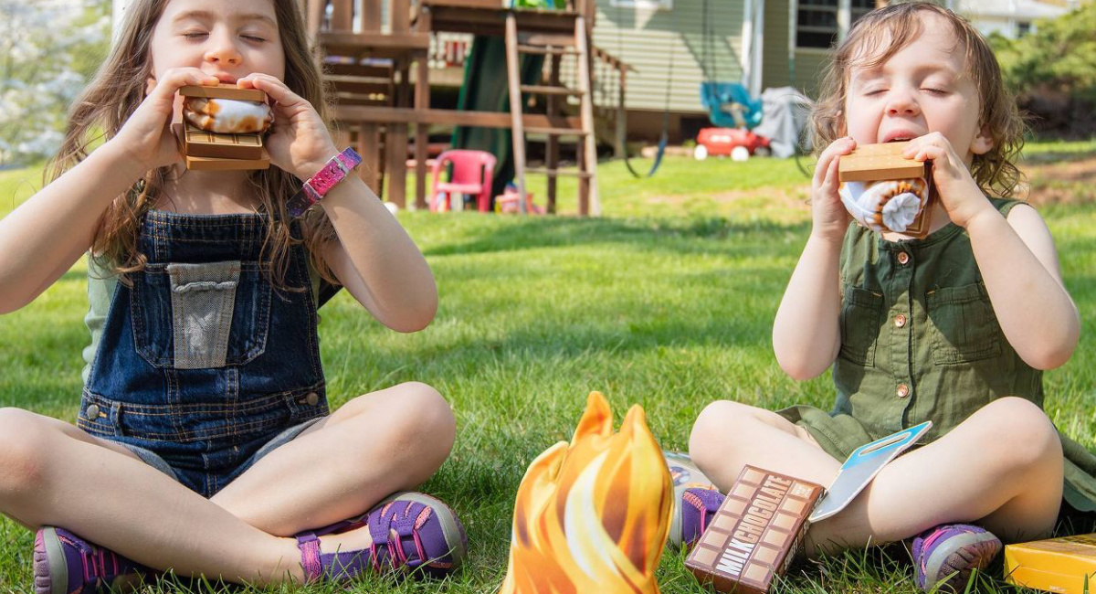 kids playing with a Melissa & Doug S'mores & More Campfire Play Set on the grass
