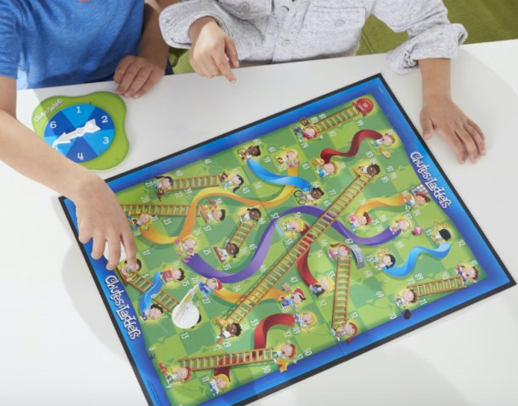two kids playing chutes and ladders board game for kids