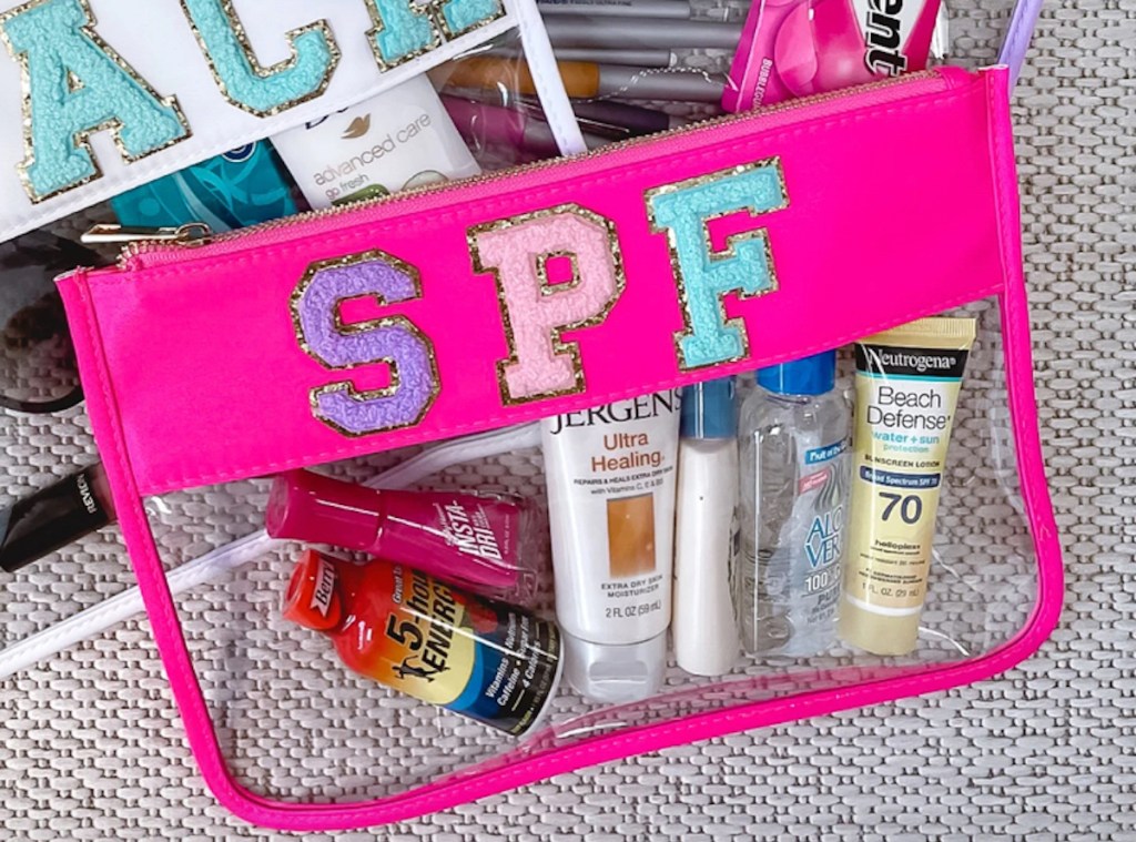 spf bright pink and clear cosmetic bag on carpet