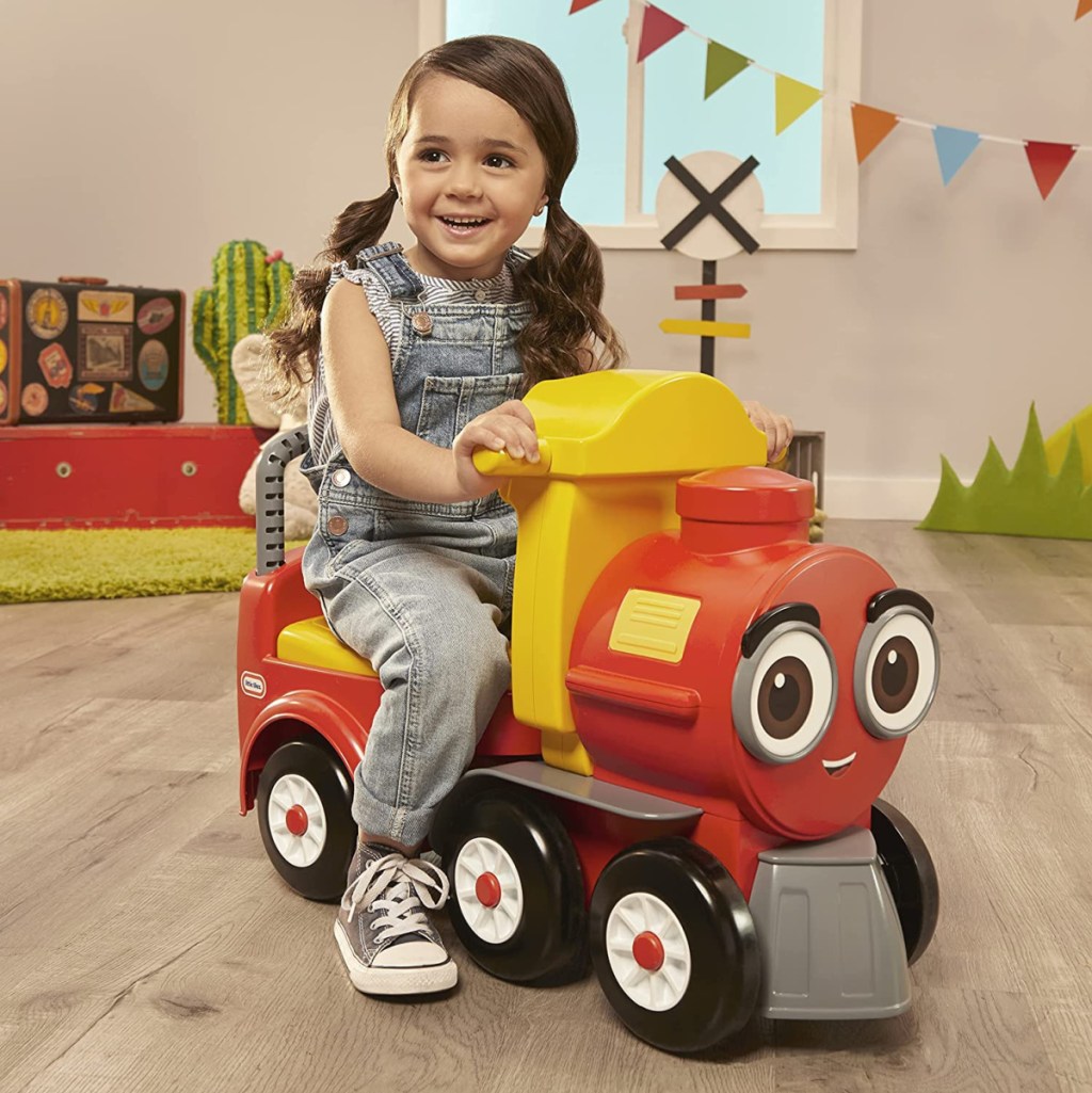 girl riding on a cozy train scoot little tikes ride on toy