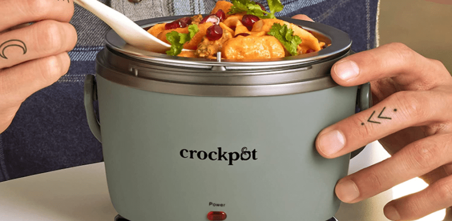 person taking food from lunch crockpot