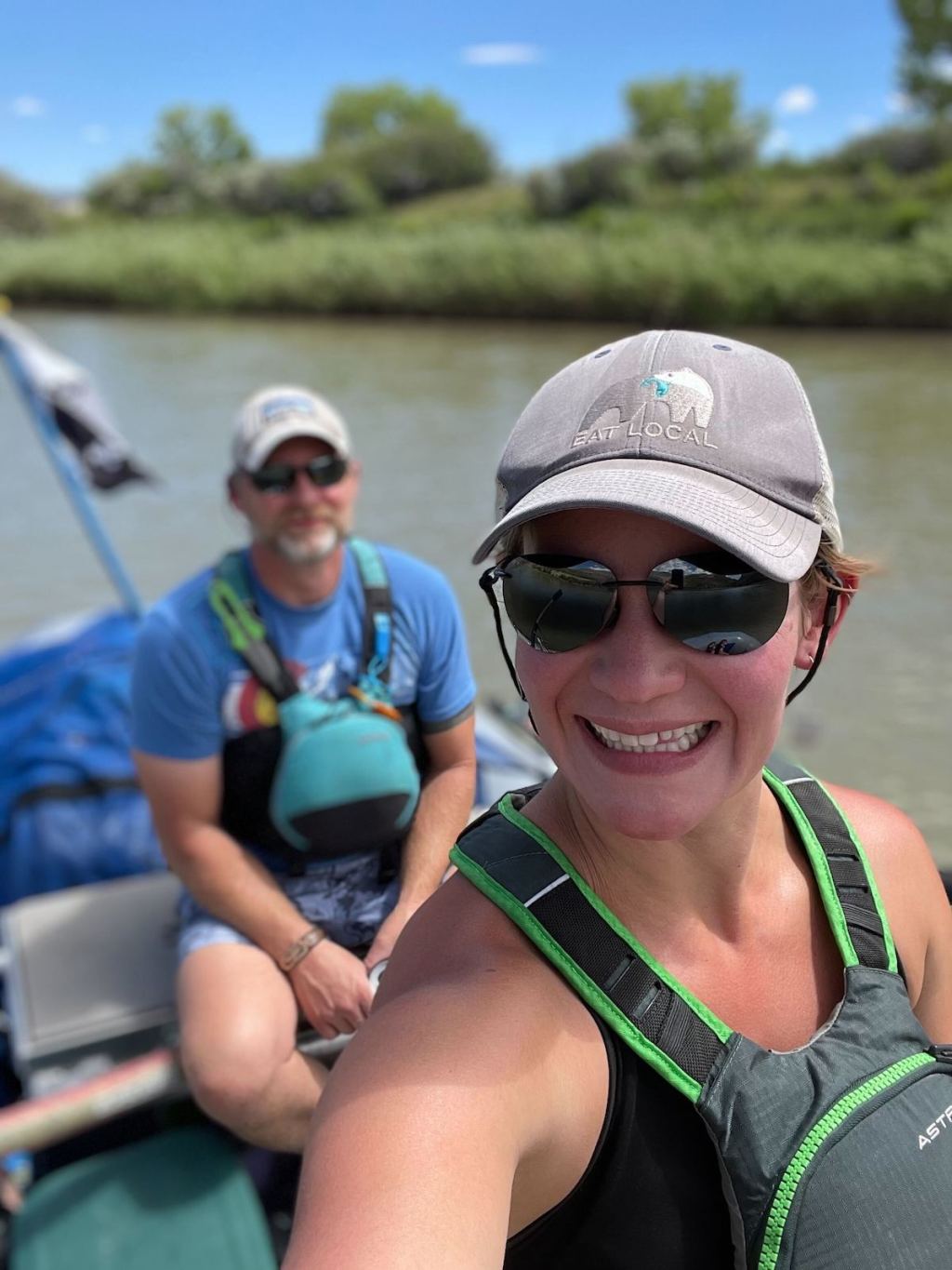 woman and man smiling at camera rafting