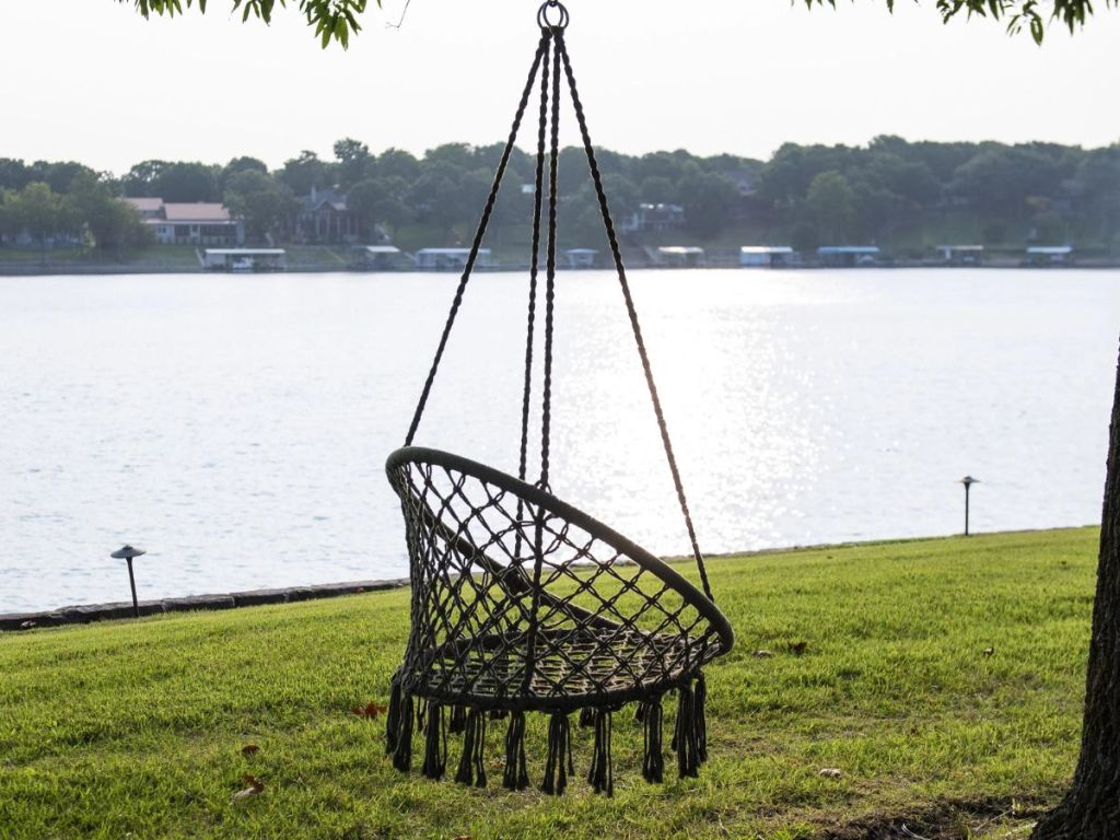 green braided hammock chair hanging from tree