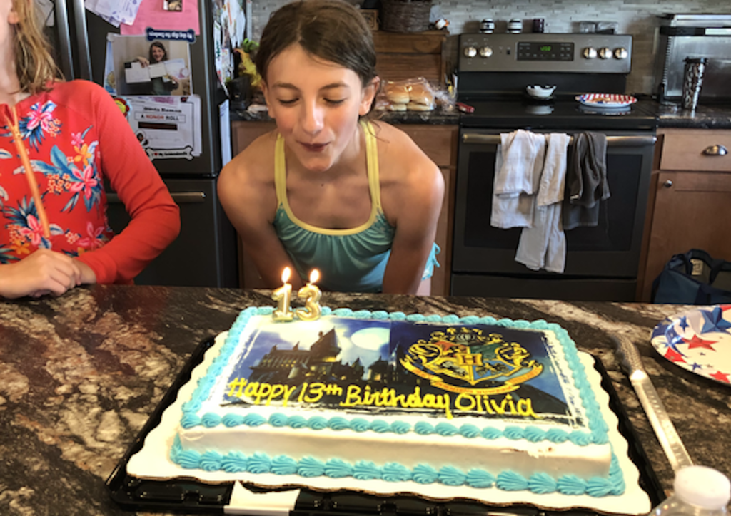 girl blowing out candles on harry potter birthday cake