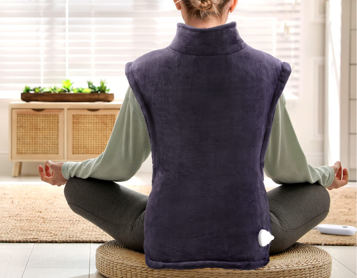 woman doing yoga wearing a purple heating pad