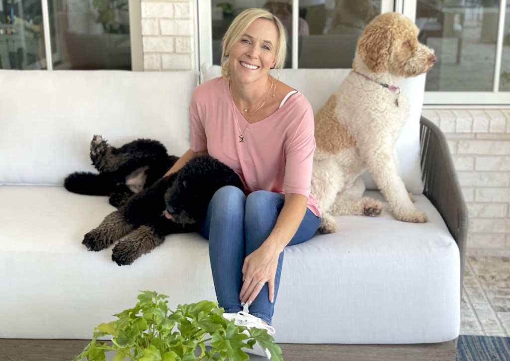 woman sitting with dogs on white couch