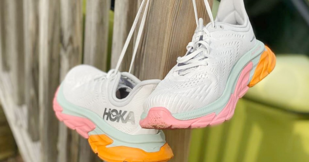 hoka running shoes hanging from fence