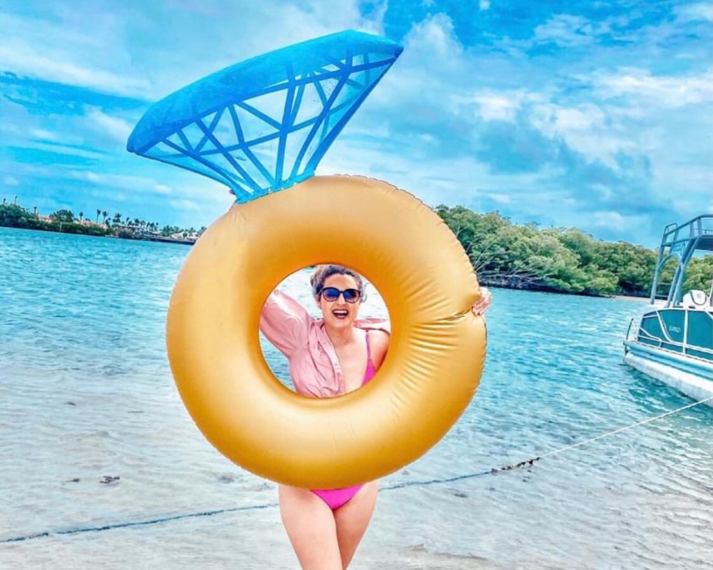 woman holding inflatable shaped like diamond ring