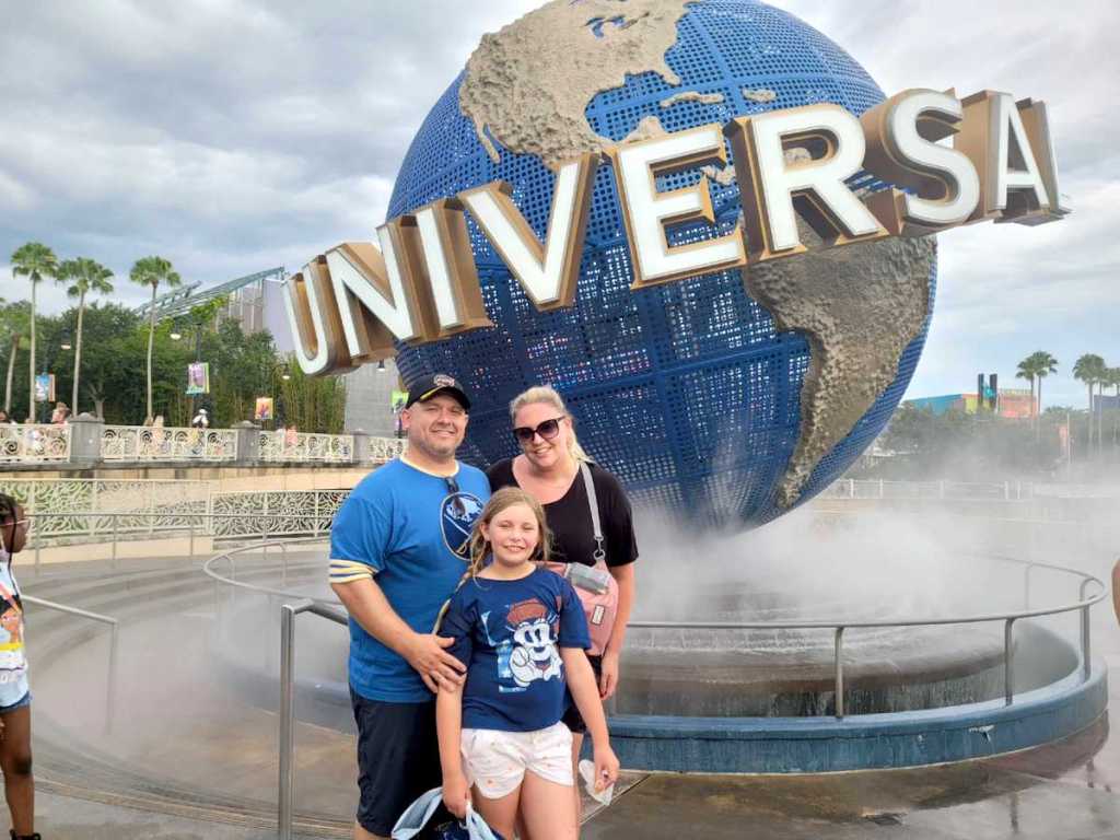 family standing in front of universal florida sign