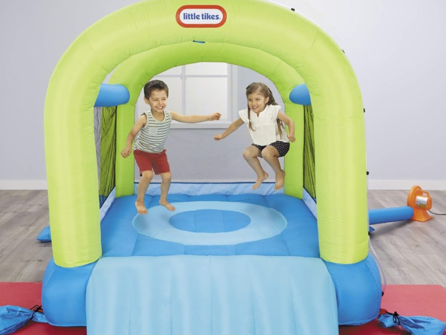 kids using little tikes bounce house inside of the living room