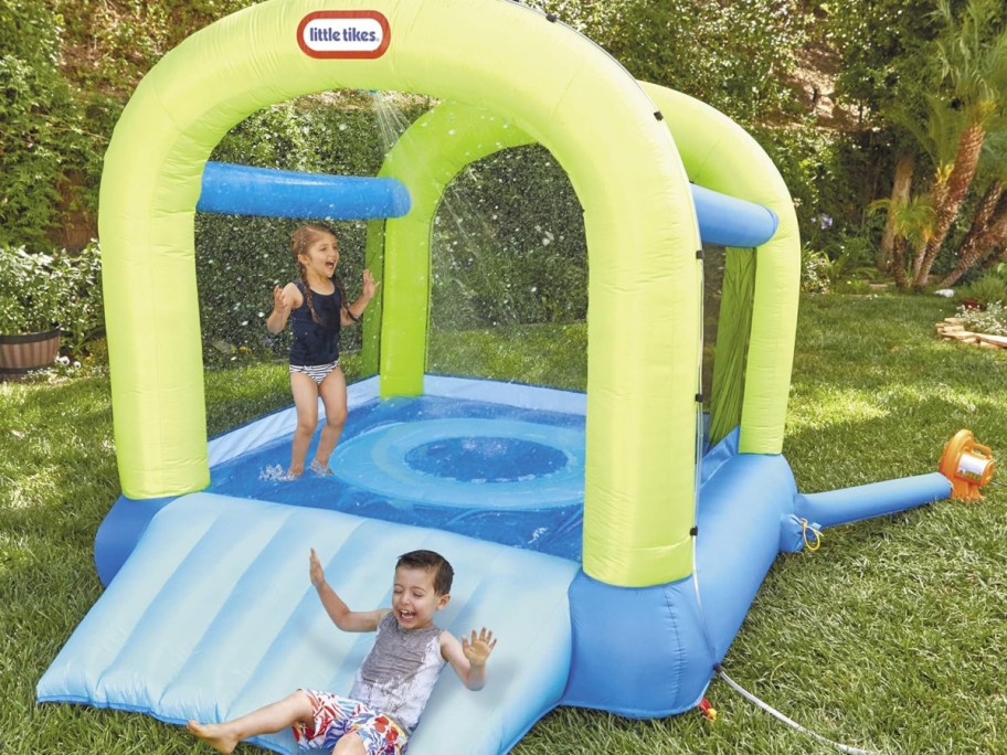 kids using little tikes bounce house sitting on the ground