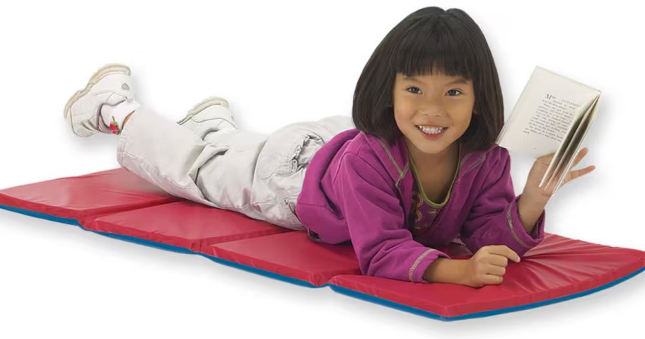 girl laying on red and blue kindermat