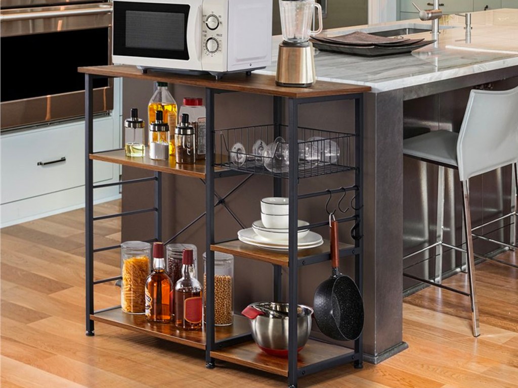 metal and wood bakers rack with microwave , fruit bowls and other items on shelf