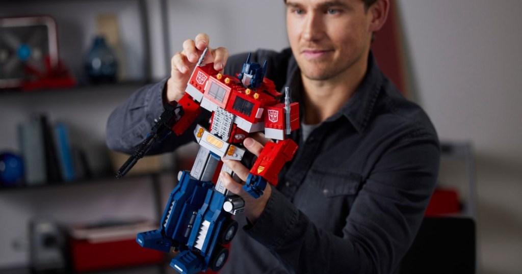 man holding LEGO optimus prime