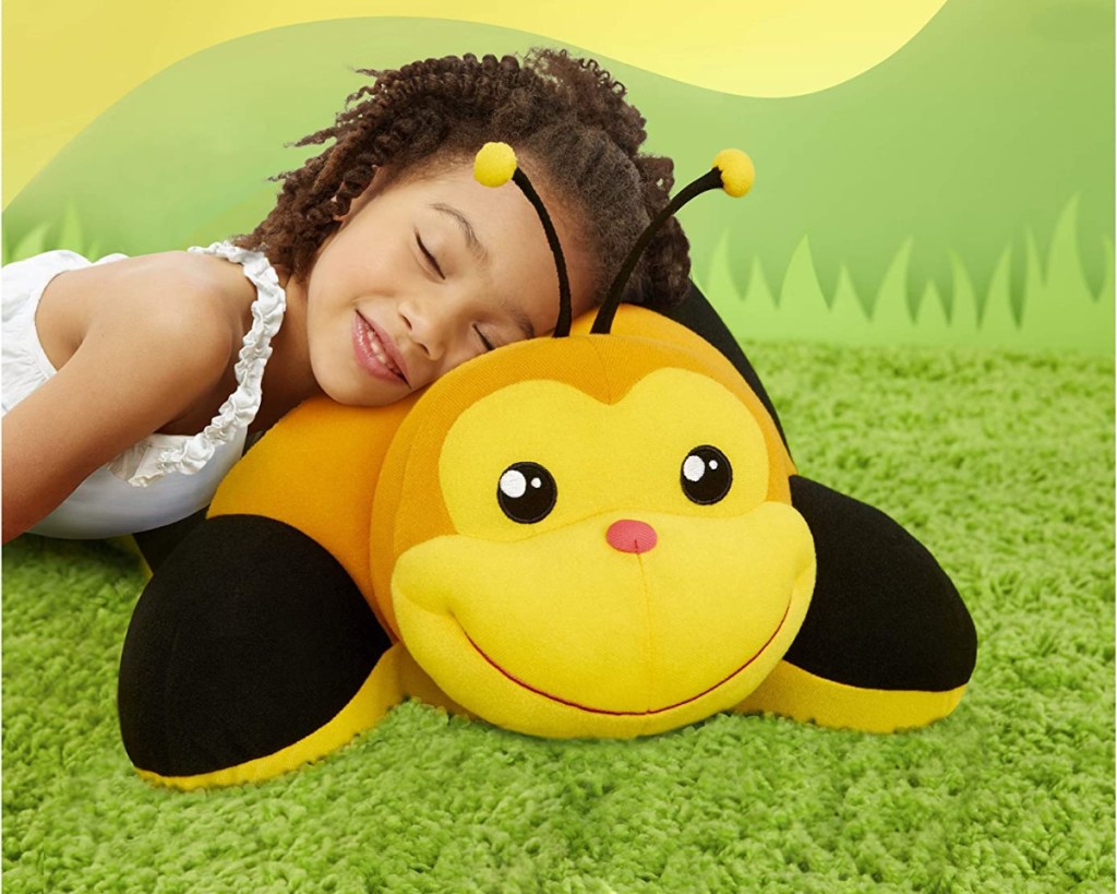girl laying on bee plush