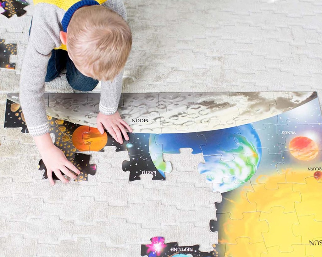 boy doing puzzle on floor