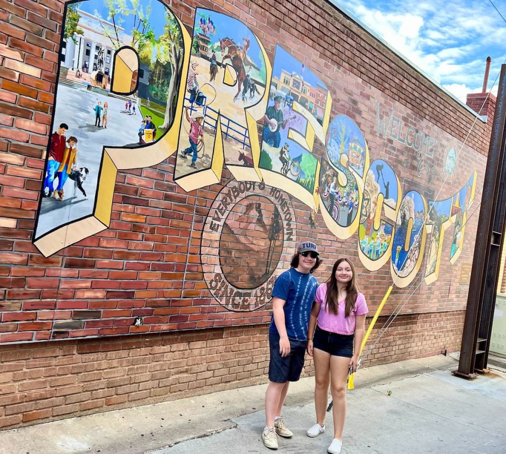 teens standing in front of prescott artwork brick wall