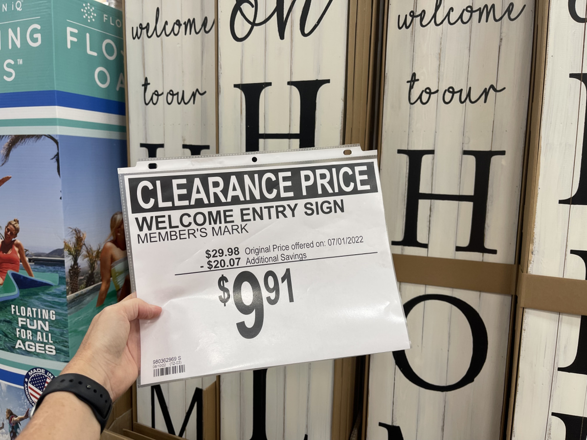 hand holding a sams club clearance sign for wooden welcome signs