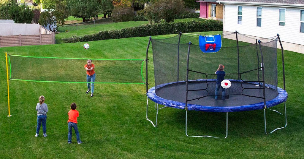 kids playing with skywalker 15 ft round trampoline with volleyball net
