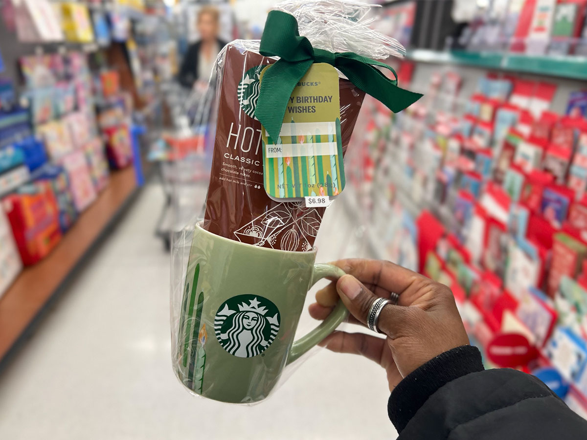 hand holding a walmart starbucks gift set in a store aisle