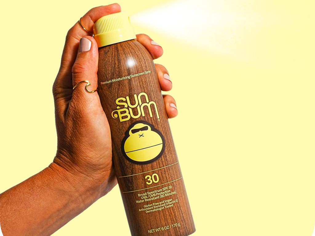 hand holding sun bum spray sunscreen