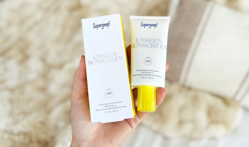 hand holding supergoop unseen sunscreen with box