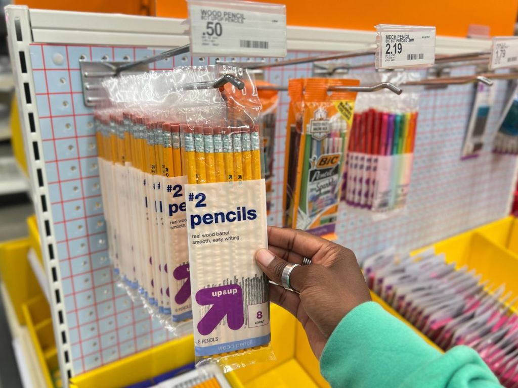 person grabbing pencils from hook in-store