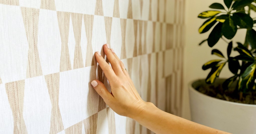 hand touching removable wallpaper