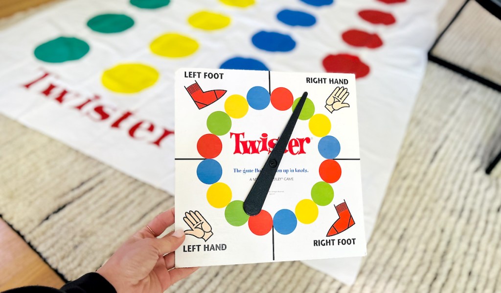 hand holding twister spinner in front of mat