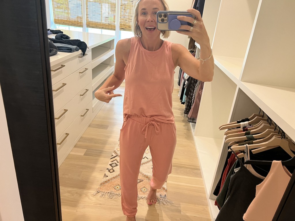 woman wearing pink two piece set taking selfie in closet