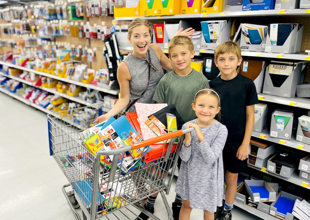 mom and kids standing in walmart school supply aisle with cart