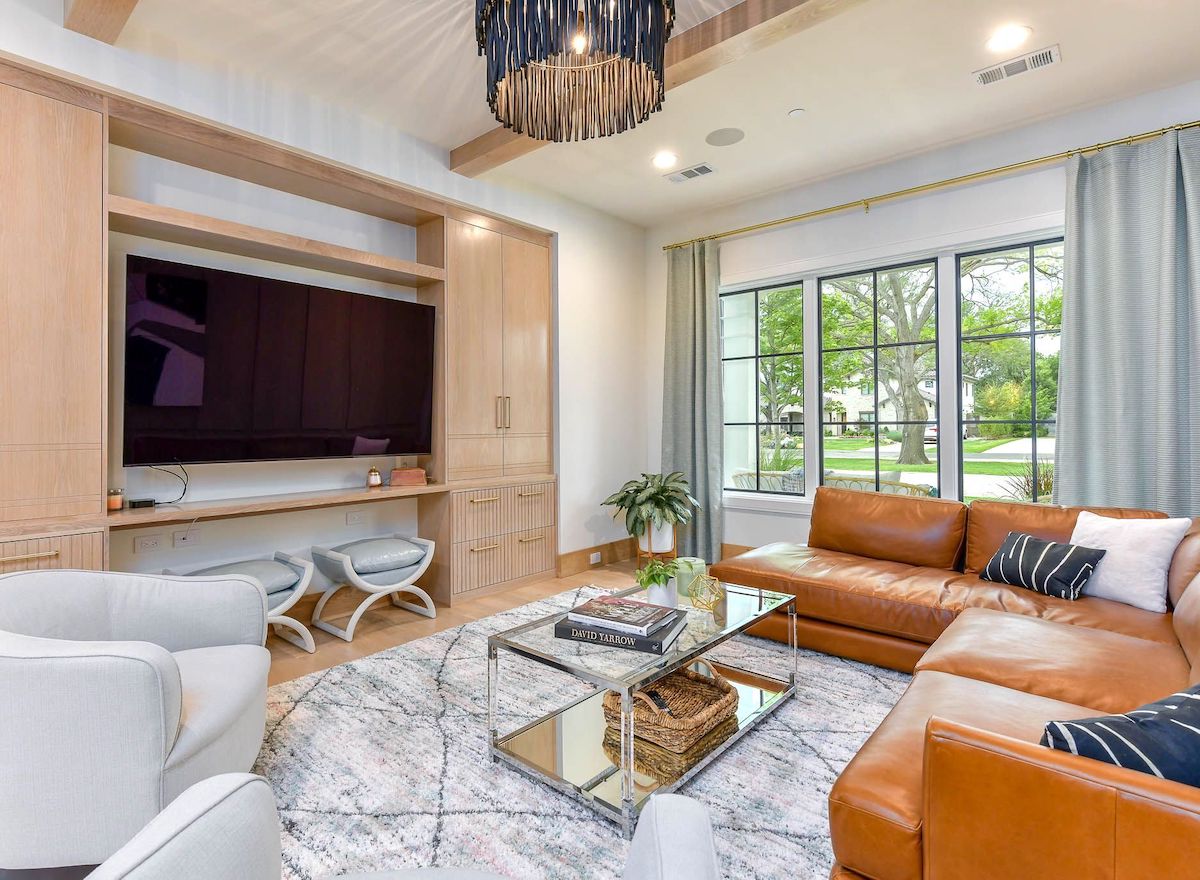 designer living room with built in cabinets and leather west elm couch sectional