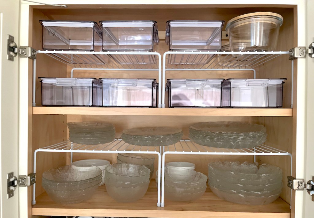 white wire shelf helpers with glass dishes and food containers stacked on top
