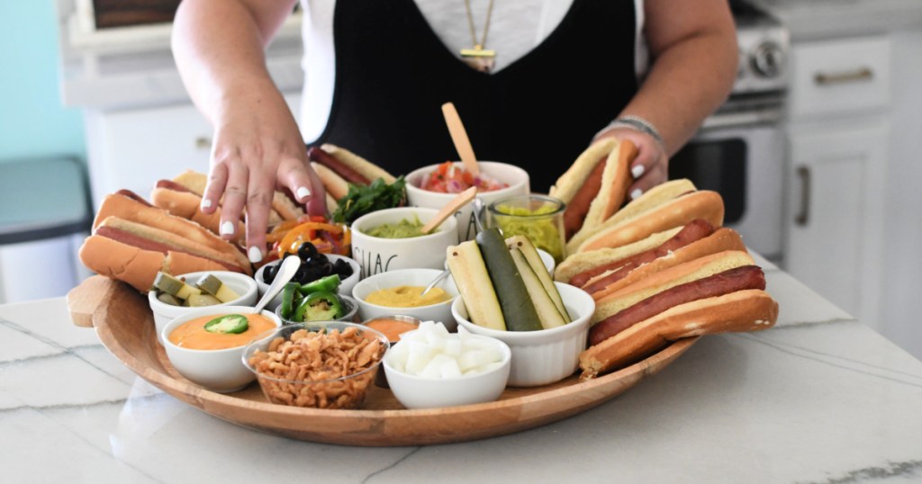 woman compiling hot dog charcuterie snack board