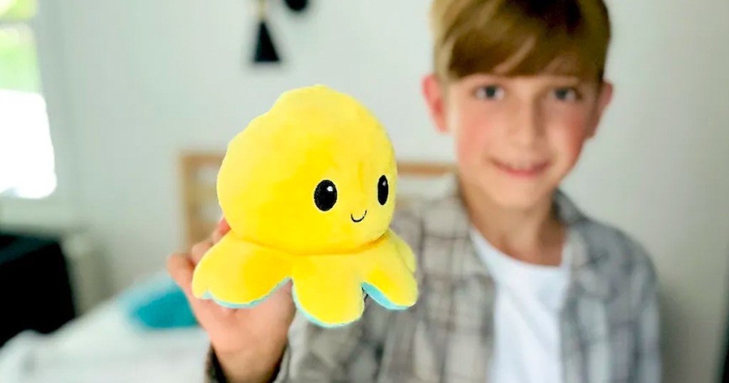 boy holding yellow ocotpus plush