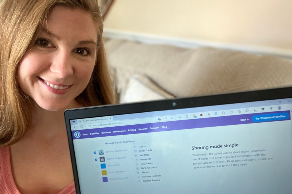 woman holding computer with 1Password sharing capabilities on screen