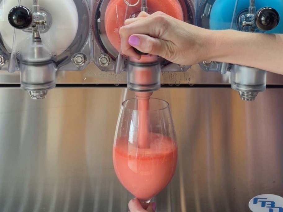 filling wine glass with pink Slurpee