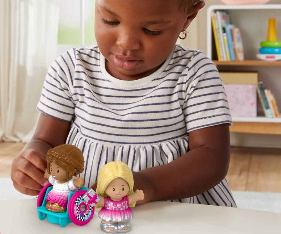 girl playing with a Barbie Party Figure Set by Fisher-Price Little People