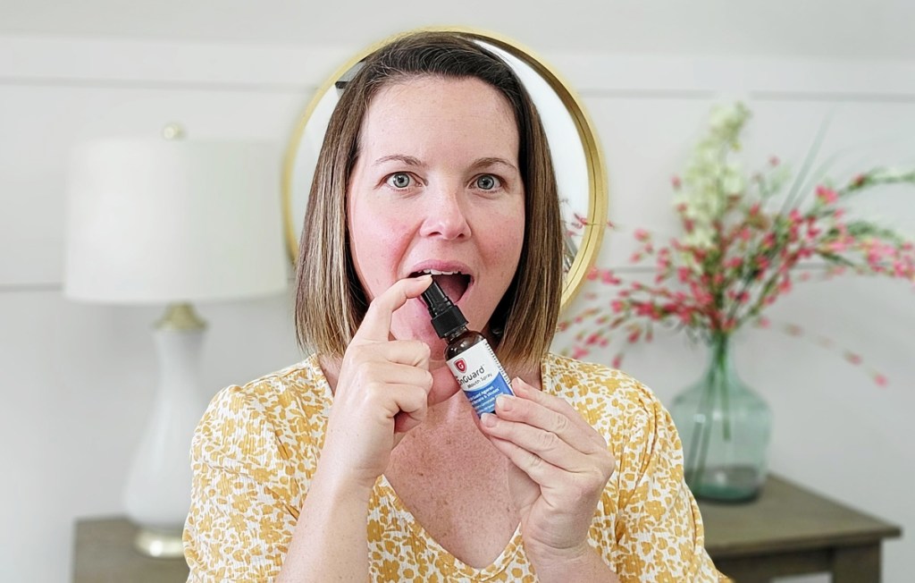 woman spraying throat spray into mouth